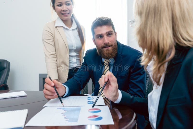 Bedrijfsanalist die terwijl het interpreteren van sh financiële verslagen glimlachen stock fotografie Bedrijfsanalist die terwijl het interpreteren van sh financiële verslagen glimlachen stock fotografie