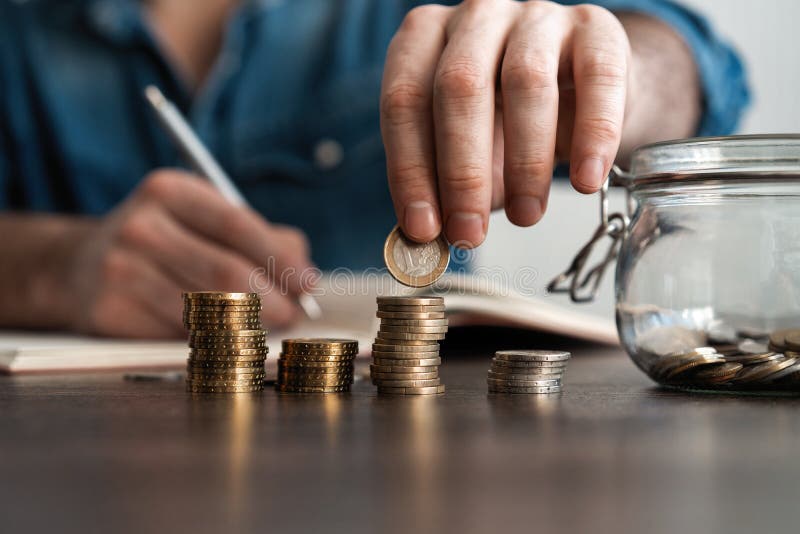 bedrijfsboekhouding met besparingsgeld met hand die muntstukken in financi?le het concept zetten van het kruikglas stock foto's bedrijfsboekhouding met besparingsgeld met hand die muntstukken in financi?le het concept zetten van het kruikglas stock foto's