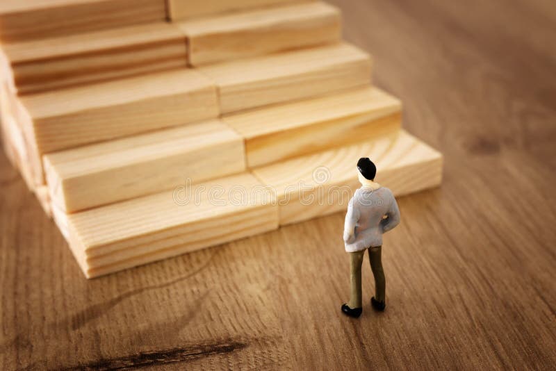 Bedrijfsconceptenbeeld van onderwijs en uitdaging Een mens bekijkt houten stappen en moet over zijn toekomst beslissen stock foto Bedrijfsconceptenbeeld van onderwijs en uitdaging Een mens bekijkt houten stappen en moet over zijn toekomst beslissen stock foto