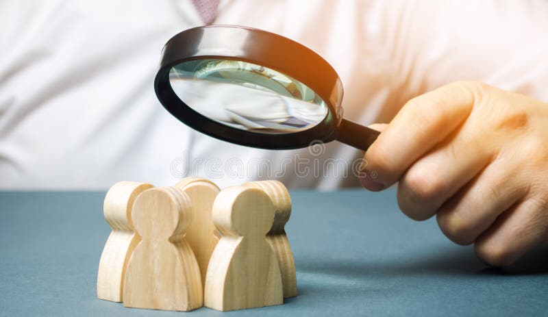 Bedrijfsleider die een vergrootglas over een team van arbeiders houden Het concept het vinden van nieuwe werknemers Teamliding te stock foto Bedrijfsleider die een vergrootglas over een team van arbeiders houden Het concept het vinden van nieuwe werknemers Teamliding te stock foto