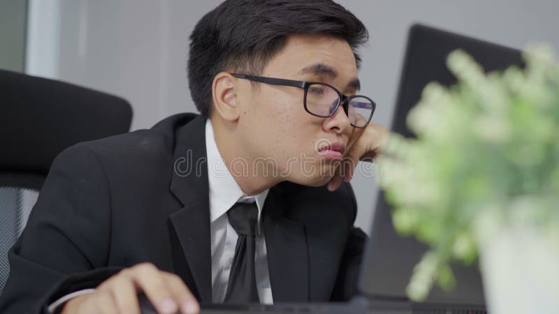 Bedrijfsmens slaperig op werkend bureau tussen het gebruiken van laptop computer