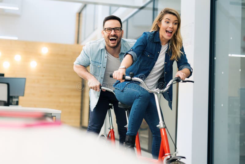 Bedrijfsmensen die pret hebben die een fiets berijden stock fotografie Bedrijfsmensen die pret hebben die een fiets berijden stock fotografie