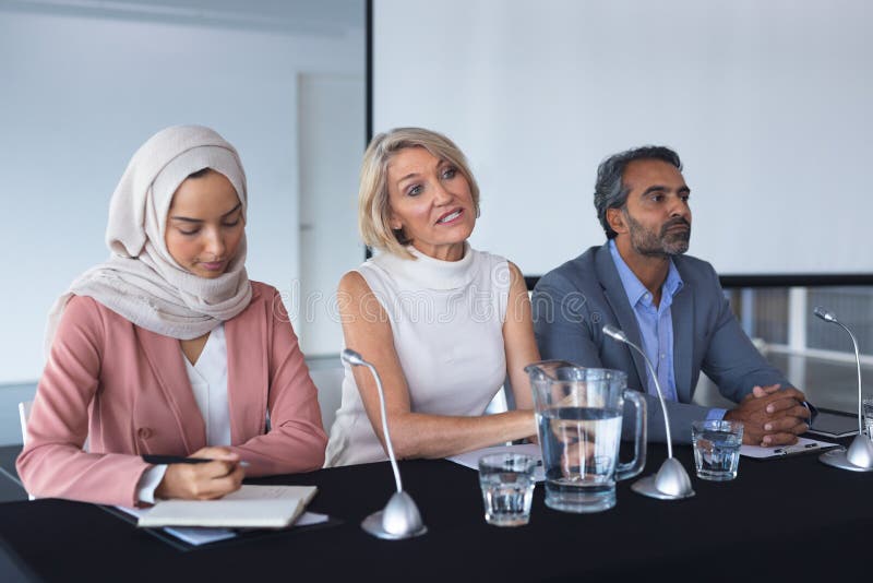 Bedrijfsmensen die samen bij lijst in conferentie zitten stock afbeeldingen Bedrijfsmensen die samen bij lijst in conferentie zitten stock afbeeldingen