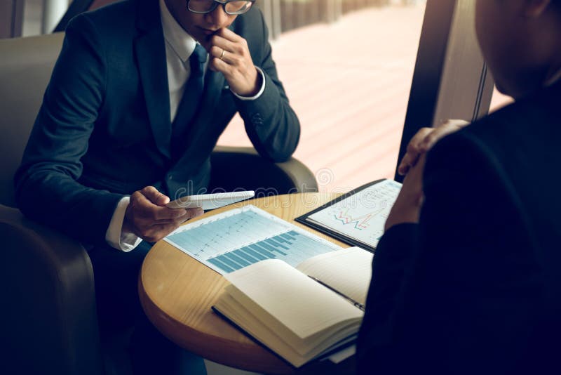 Business partnership coworkers using a tablet to chart company financial statements report and profits work progress and planning in office room. Business partnership coworkers using a tablet to chart company financial statements report and profits work progress and planning in office room.