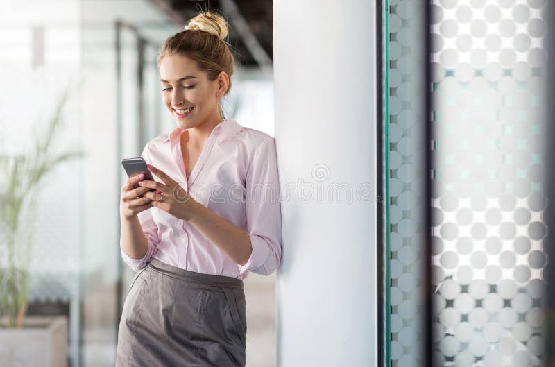 Bedrijfsvrouw die smartphone in bureau gebruiken royalty-vrije stock foto's Bedrijfsvrouw die smartphone in bureau gebruiken royalty-vrije stock foto's