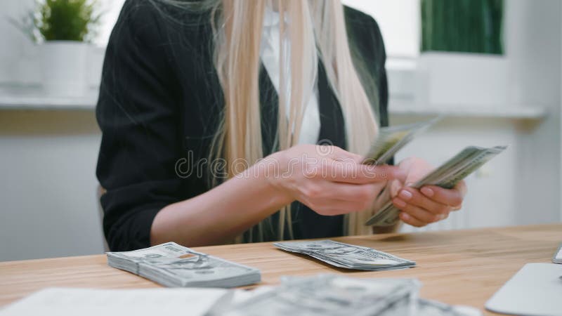 Bedrijfsvrouwen tellend contant geld in handen Gewassenmening van wijfje in elegante kostuumzitting bij houten bureau en groot te