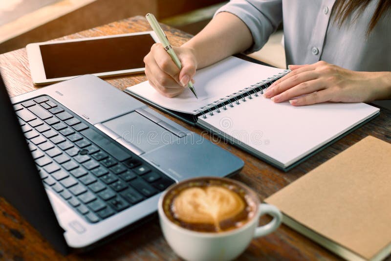 Bedrijfsvrouwenzitting bij lijst en het nemen van nota's in notitieboekje Op royalty-vrije stock afbeeldingen Bedrijfsvrouwenzitting bij lijst en het nemen van nota's in notitieboekje Op royalty-vrije stock afbeeldingen