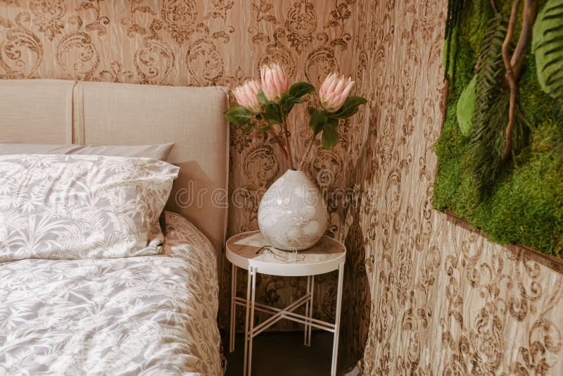 Bedside Table with Vase and Red Flowers in the Bedroom. Vintage Style