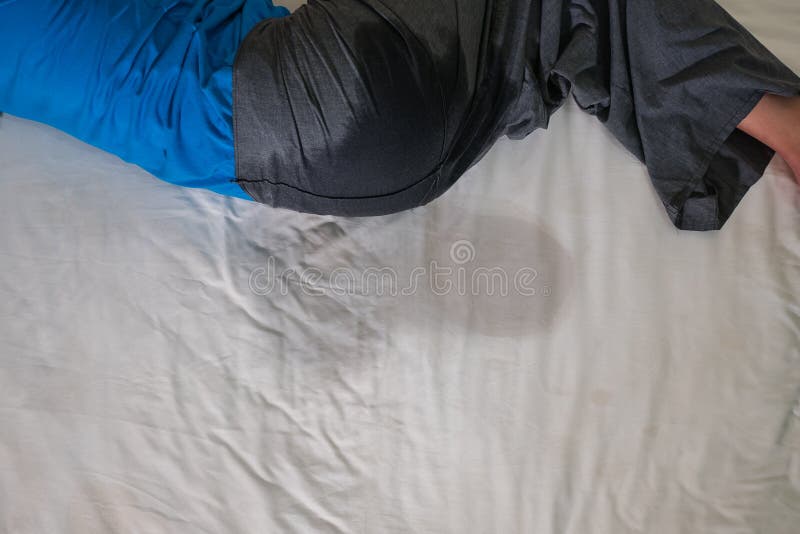 Bedwetting, o enuresis nocturna en adultos, pis en una hoja de cama blanca o colchón en sueño de la noche imágenes de archivo libres de regalías Bedwetting, o enuresis nocturna en adultos, pis en una hoja de cama blanca o colchón en sueño de la noche imágenes de archivo libres de regalías
