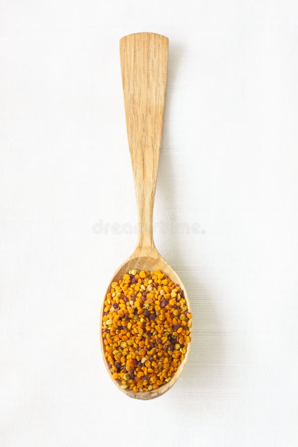 Bee pollen granules in a wooden spoon on white background. Superfood. Copy space royalty free stock photo Bee pollen granules in a wooden spoon on white background. Superfood. Copy space royalty free stock photo