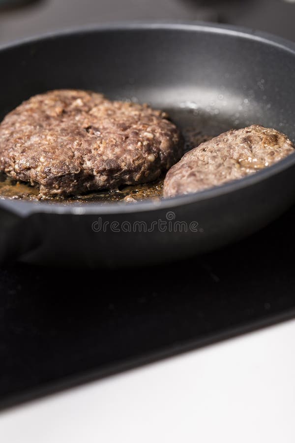 Beef Burgers Being Cooked on a Black Pan Close Up Stock Photo Image