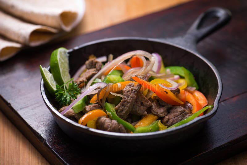 Manzo fajita nella padella con la tortilla di pane.