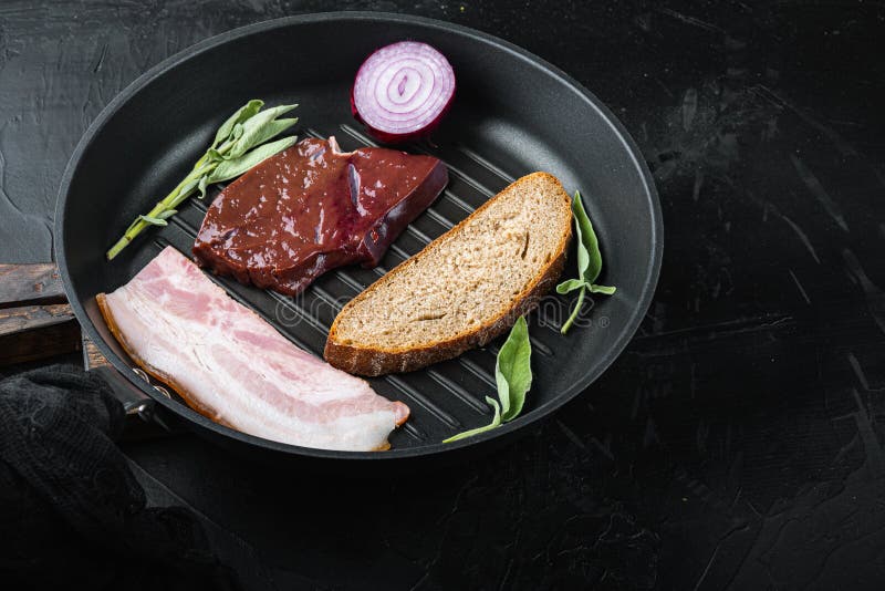 Beef Liver Sliced with Bacon on Grill Pan on Black Surface Stock Photo