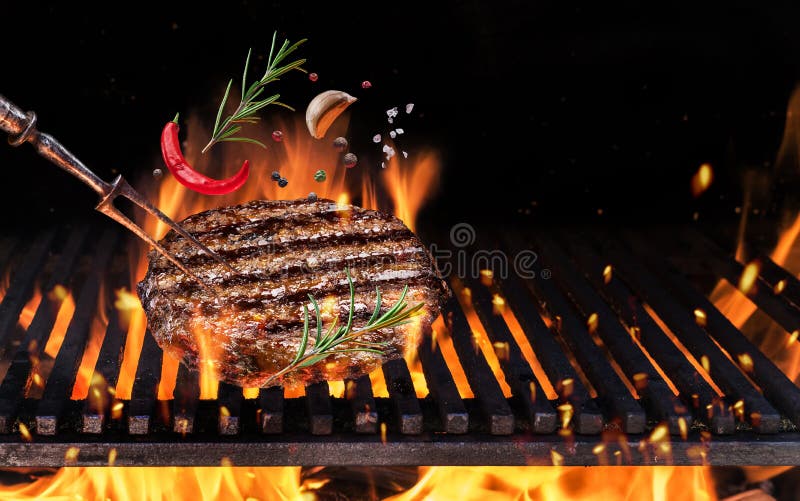 Beef milled meat on hamburger with spices fly over the flaming grill barbecue fire