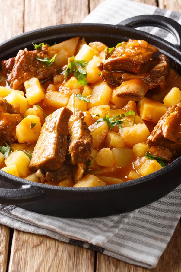 Beef Ribs Stewed with Potatoes and Gravy Closeup in a Pot. Vertical