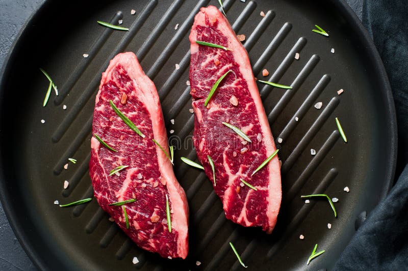 Beef Sirloin Steak on the Grill Pan. Black Background, Top View. Stock