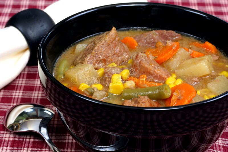 Hot bowl of rich and healthy beef stew with carrots, beans, corn and potatoes.