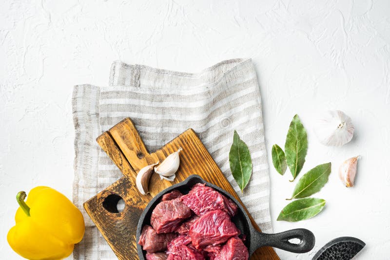 Beef Stew Raw Ingredients, in Cast Iron Frying Pan, on White Stone