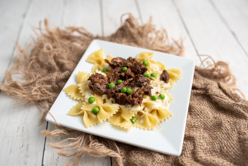 Beef Tips Over Bow Tie Pasta and Alfredo Sauce Stock Image Image of