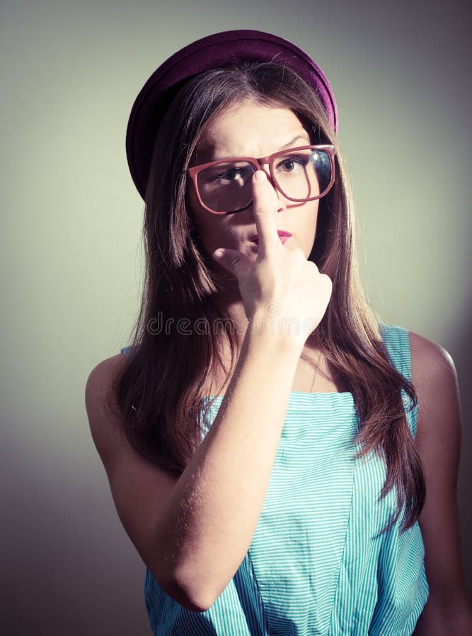 Beeld die van mooi meisje glazen dragen tegen lichte muurachtergrond stock afbeeldingen Beeld die van mooi meisje glazen dragen tegen lichte muurachtergrond stock afbeeldingen