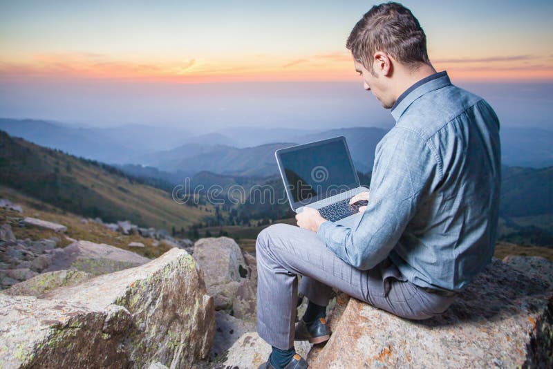 Beeld van een zakenman op de bovenkant van de berg, die laptop met behulp van stock afbeeldingen Beeld van een zakenman op de bovenkant van de berg, die laptop met behulp van stock afbeeldingen