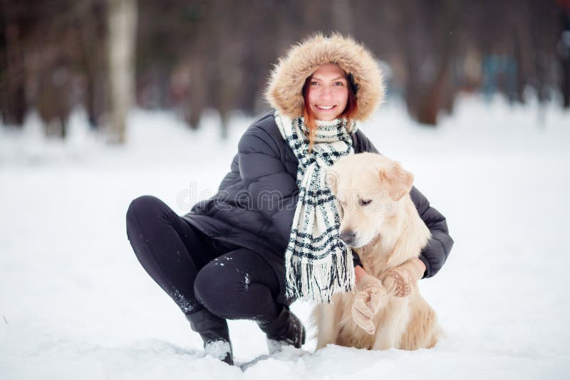 Beeld van meisje in zwart jasje die naast hond in de winter hurken royalty-vrije stock afbeeldingen Beeld van meisje in zwart jasje die naast hond in de winter hurken royalty-vrije stock afbeeldingen