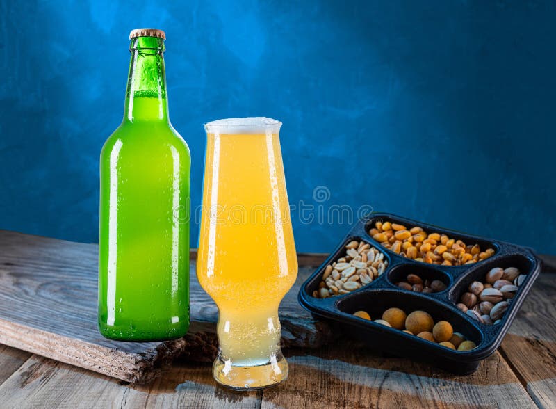 Beer Composition. Beer and Snacks. Bottle and Glass of Light Beer. Beer and Nuts. Still Life