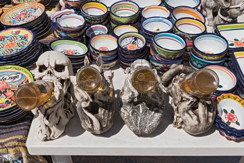 Beer drinking figures between colored ceramic bowls at a stall in mahahual, quintana roo, mexico royalty free stock photo Beer drinking figures between colored ceramic bowls at a stall in mahahual, quintana roo, mexico royalty free stock photo