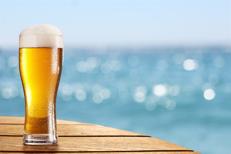 Beer glass on a blurred background of the sea. stock photos