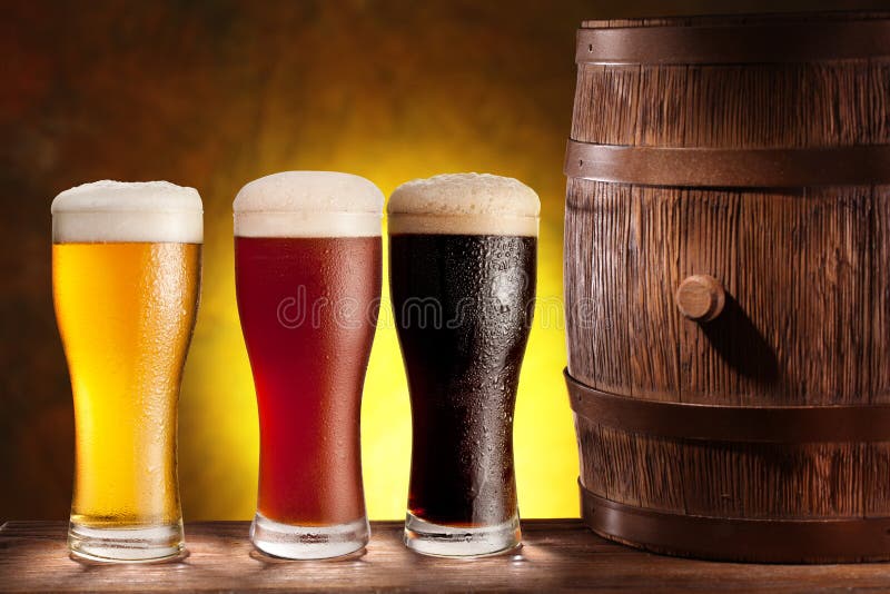 Beer glasses with a wooden barrel. stock image