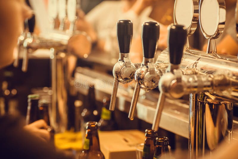 Beer Tap with Fresh Brewed Drink in Busy Pub in Europe Stock Image