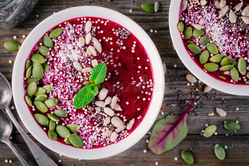 Beet smoothie bowl with chia seeds, coconut, pumpkin seeds, quinoa, sunflower seeds and mint stock image Beet smoothie bowl with chia seeds, coconut, pumpkin seeds, quinoa, sunflower seeds and mint stock image