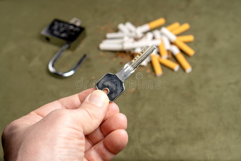 Befreiung vom Rauchen Der Schl?ssel auf dem Hintergrund von defekten Zigaretten und von offenen Verschluss lizenzfreies stockfoto Befreiung vom Rauchen Der Schl?ssel auf dem Hintergrund von defekten Zigaretten und von offenen Verschluss lizenzfreies stockfoto