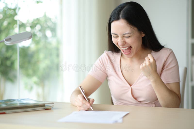 Begeisterte asiatische Frau, die zu Hause einen Vertrag unterzeichnet hat lizenzfreie stockfotografie