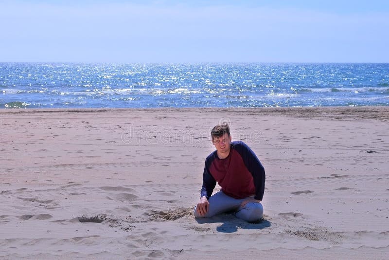 Beginner tired man fall on the sand beach after jogging at seaside. stock image Beginner tired man fall on the sand beach after jogging at seaside. stock image