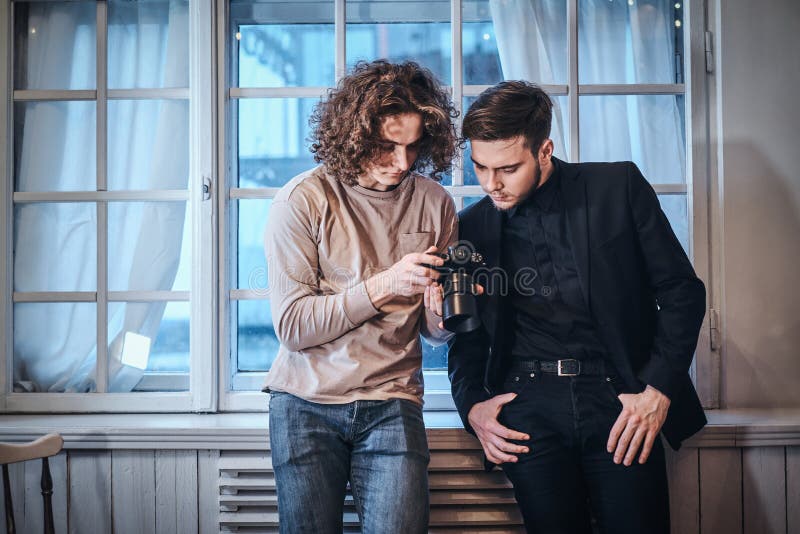Beginnerfotograaf die de resulterende foto's met zijn klant in de studio doorbladeren royalty-vrije stock afbeelding Beginnerfotograaf die de resulterende foto's met zijn klant in de studio doorbladeren royalty-vrije stock afbeelding