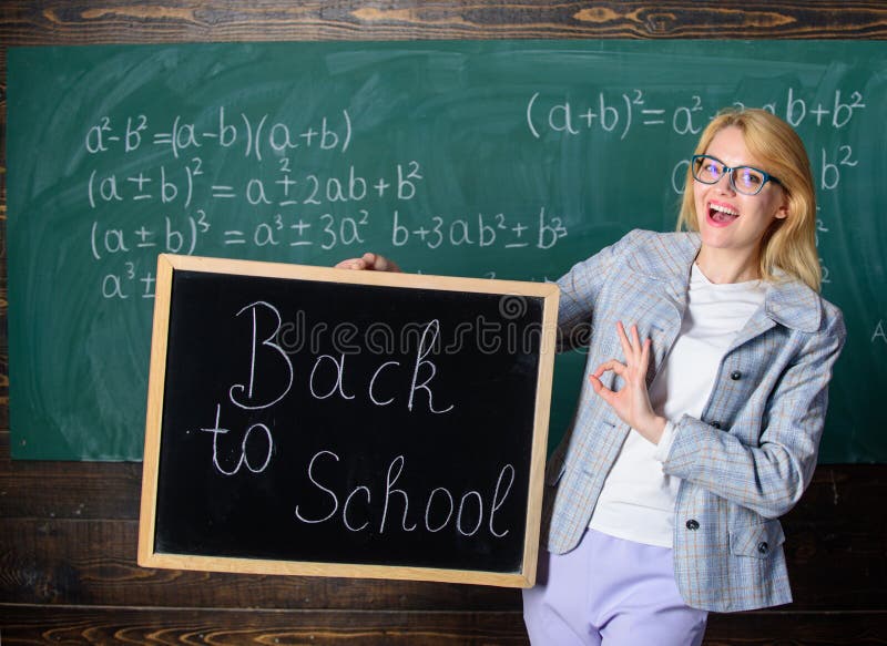 Beginning of new school season. Woman teacher holds blackboard inscription back to school. Are you ready to study. Lady