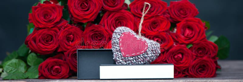 Begrepp av en gåva för valentin dag stor grupp av röda rosor och en öppen ask med ett stilfullt, arkivfoto Begrepp av en gåva för valentin dag stor grupp av röda rosor och en öppen ask med ett stilfullt, arkivfoto