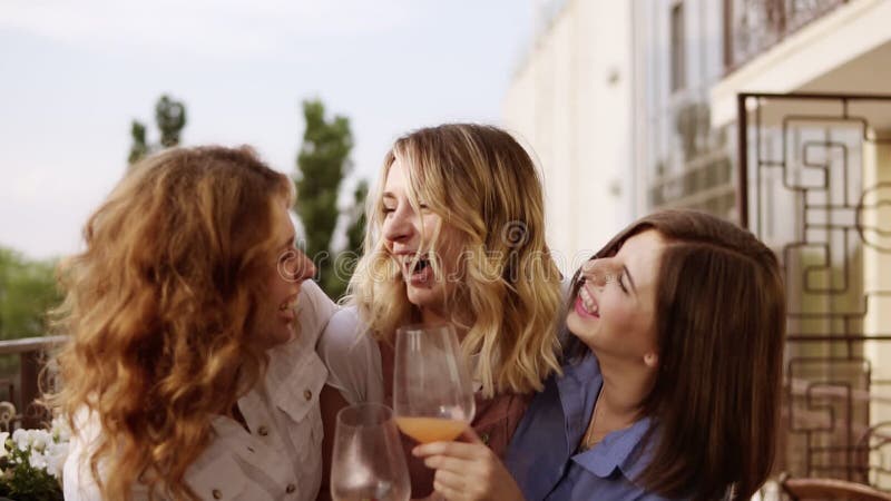 Begrepp av möhippan Tre härliga kvinnor som tillsammans dricker coctailar på en terrass Kvinnor som pratar och skrattar långsamt