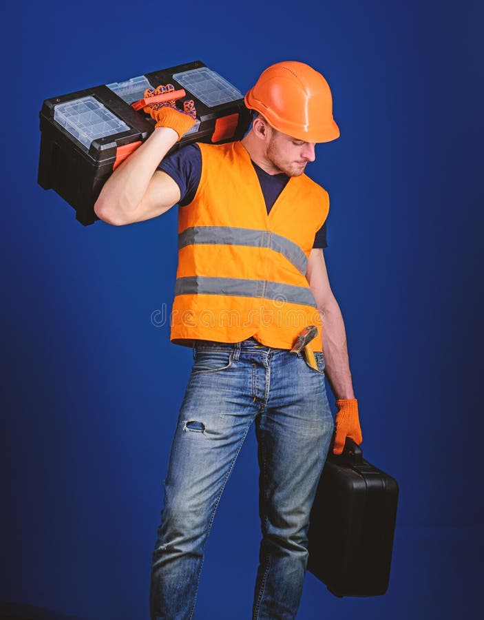 Begrepp f?r reparationsservice Mannen i hj?lm, den h?rda hatten rymmer toolboxen och resv?skan med hj?lpmedel, bl? bakgrund Arbet arkivfoton Begrepp f?r reparationsservice Mannen i hj?lm, den h?rda hatten rymmer toolboxen och resv?skan med hj?lpmedel, bl? bakgrund Arbet arkivfoton