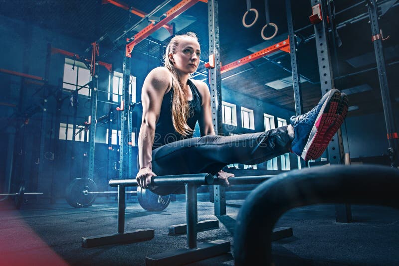 Begrepp: makt styrka, sund livsstil, sport Kraftig attraktiv muskulös kvinna på den CrossFit idrottshallen royaltyfri bild Begrepp: makt styrka, sund livsstil, sport Kraftig attraktiv muskulös kvinna på den CrossFit idrottshallen royaltyfri bild
