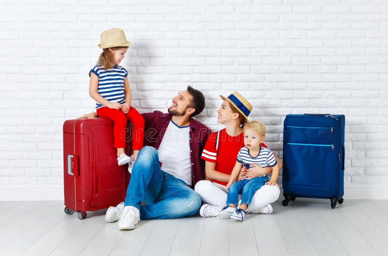 Begreppslopp och turism den lyckliga familjen med resväskor near w royaltyfri fotografi Begreppslopp och turism den lyckliga familjen med resväskor near w royaltyfri fotografi