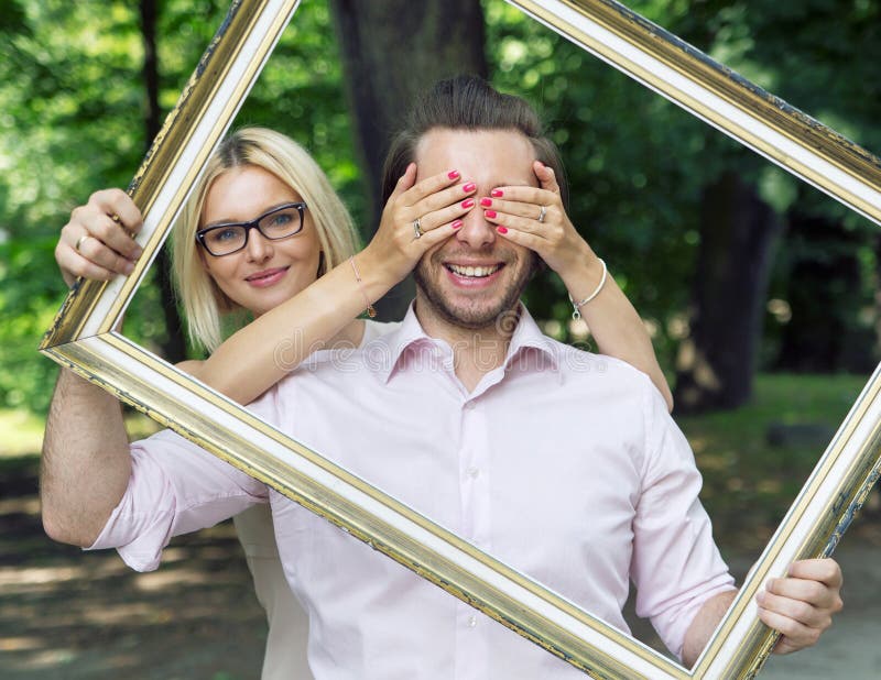 Begreppsmässig bild av paren som rymmer en ram arkivfoto Begreppsmässig bild av paren som rymmer en ram arkivfoto