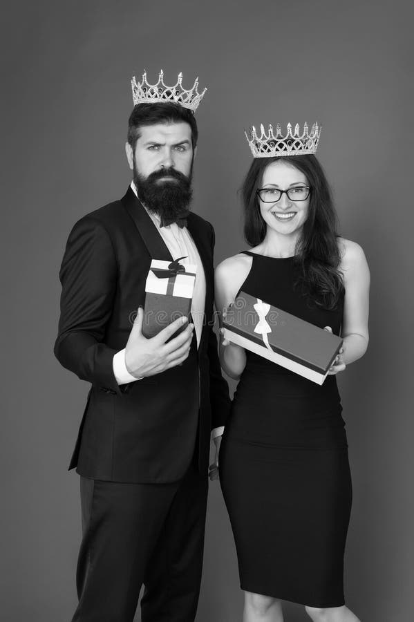 Begåvad. framgångsmål. vackra människor firar framgång. Ett par i kärleken bär kronornas röda bakgrund royaltyfria bilder