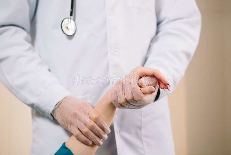 Behandeln Sie das Halten der Hand des Mädchens und misst den Impuls des Patienten lizenzfreie stockbilder Behandeln Sie das Halten der Hand des Mädchens und misst den Impuls des Patienten lizenzfreie stockbilder