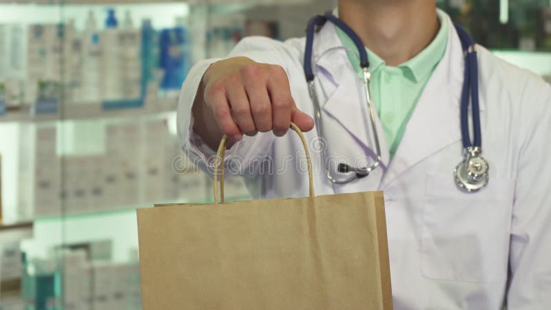Behandeln Sie das Lächeln und das Halten eines Pakets im Drugstore stockbilder Behandeln Sie das Lächeln und das Halten eines Pakets im Drugstore stockbilder