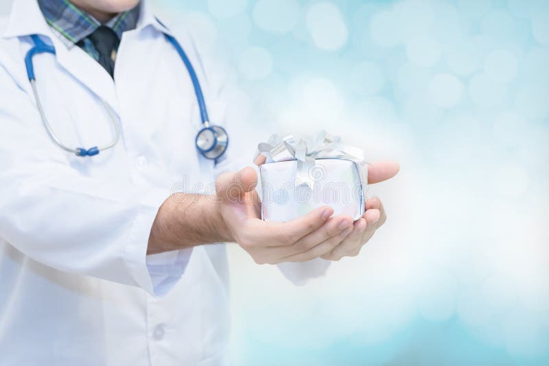 Behandeln Sie die Hände, die Geschenkbox mit Band, Geschenke für Patientenkonzept halten stockbild Behandeln Sie die Hände, die Geschenkbox mit Band, Geschenke für Patientenkonzept halten stockbild