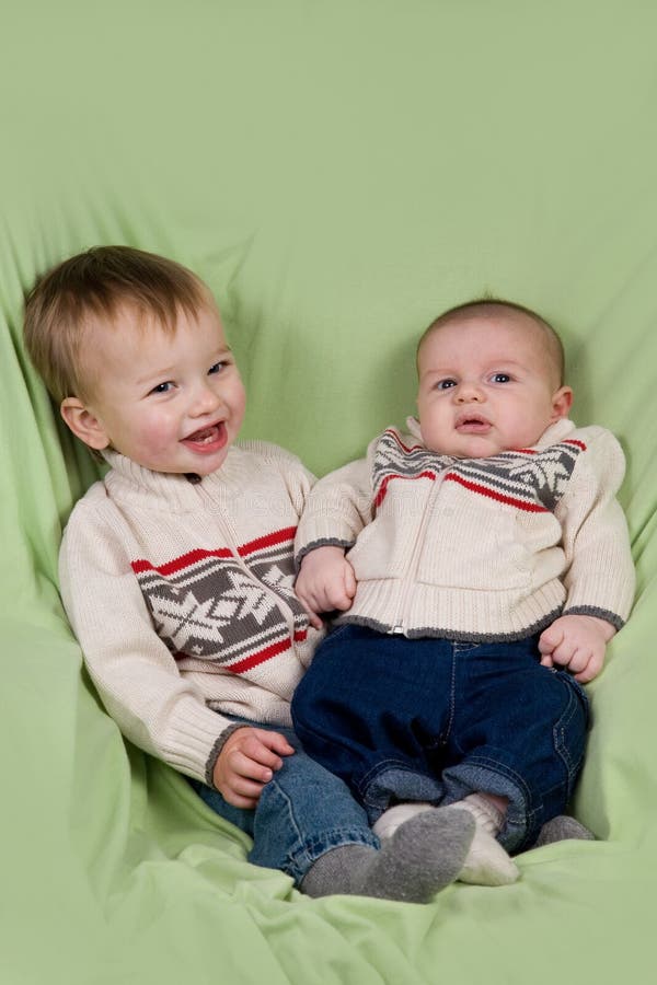 A portrait of two baby boys (cousins) in winter clothes. A portrait of two baby boys (cousins) in winter clothes.