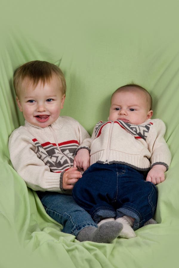 A portrait of two baby boys (cousins) in winter clothes. A portrait of two baby boys (cousins) in winter clothes.