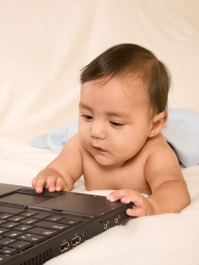 Kid playing with portable computer, surfing net, checking e-mail, playing games. That's the sign of modern time, early childhood addiction to computers and technology. Kid playing with portable computer, surfing net, checking e-mail, playing games. That's the sign of modern time, early childhood addiction to computers and technology